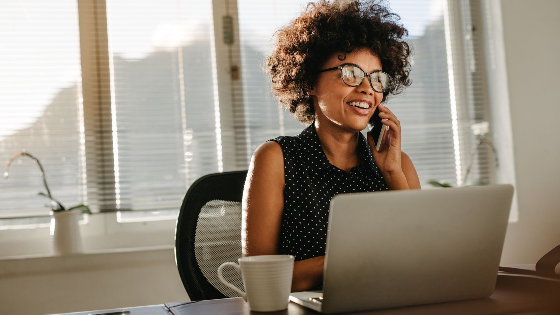 A female employee who looks happy while talking to someone on the phone